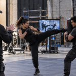 Stunt coordinator supervising performers during a high-impact choreography rehearsal